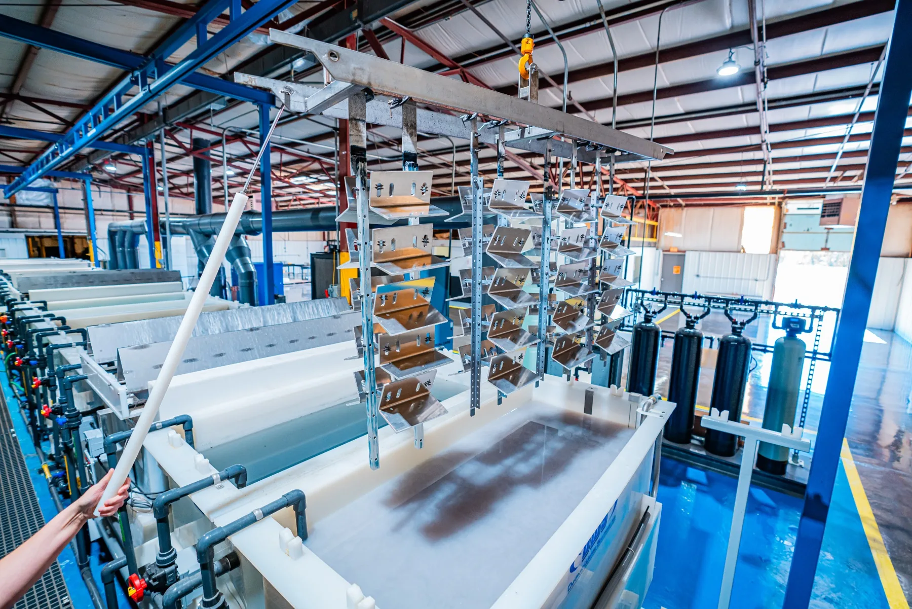 Racked aluminum parts over the anodizing line at the AnoPRO plant in Paoli, Indiana